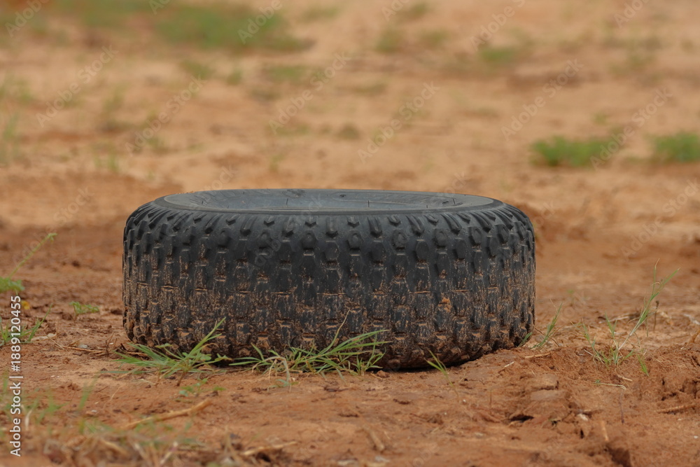 Obraz premium tire on the ground in the field, closeup of photo