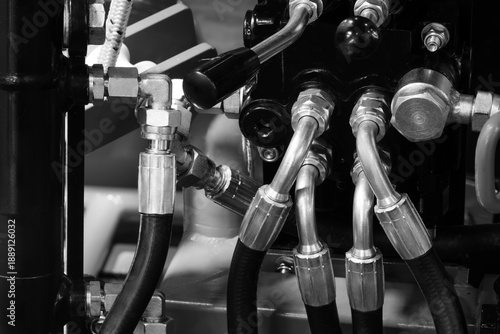 Electrical wires and hydraulic hoses are connected to a large industrial production machine conveyor, industrial background