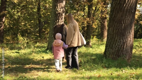 Wallpaper Mural Young mother and her little daughter petting a horse together during a family walk in autumn woods Torontodigital.ca