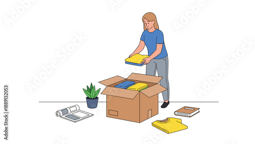 A woman packing items into a cardboard box, placing yellow and blue folded clothes and other objects, with a potted plant nearby, suggesting organization or moving.