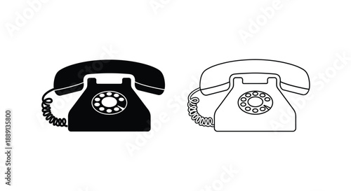 Two vintage rotary telephones one black one white side by side