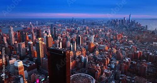 Descend along the tower of One Penn Plaza in New York, USA. Vast perspective eon the metropolis at sunset time.
