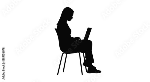 Silhouette of a woman seated in a chair using a laptop