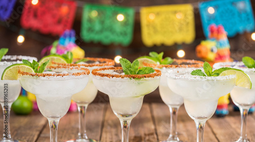 A row of classic margarita cocktails with lime and salt for a party. Festive Mexican fiesta background for a Cinco de Mayo celebration