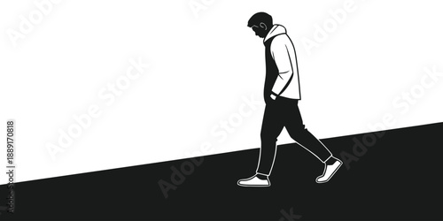 A young man walks with hands in pockets against a stark contrasting background silhouette high quality