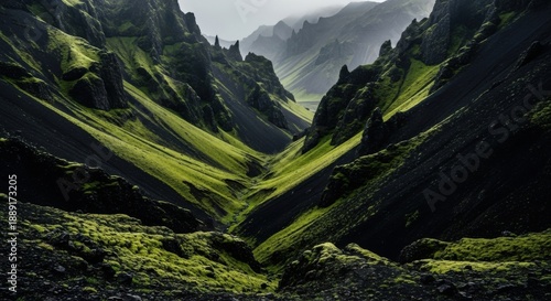 Dramatic green valley between rugged black mountains