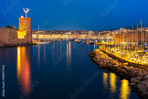 Marseille, Provence, France: Entrance into the Old Port of Marseille by the Fort of Saint John illuminated at twilight blue hour