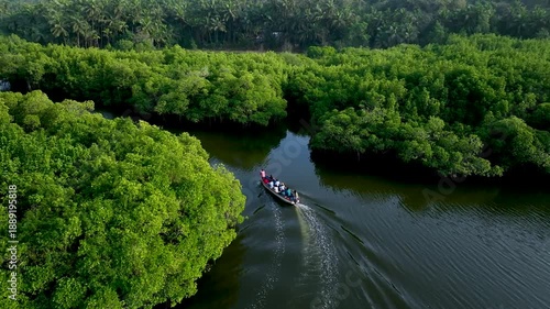 Aerial drone view of lush green mangrove forest with traditional fishing boats along calm coastal backwaters, showcasing tropical ecosystem, rural fishing lifestyle, natural landscape, and peaceful en