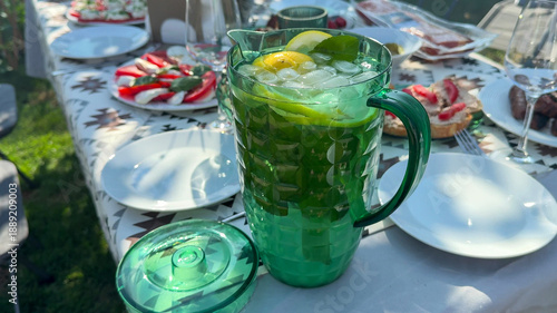 Fotografía Chilled citrus pitcher gleams under sun-kissed picnic, sparkling festivity of Ob