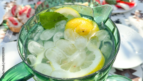 Schilderij op canvas Chilled lemon potion in emerald pitcher, zesty summer solstice refreshment, cool