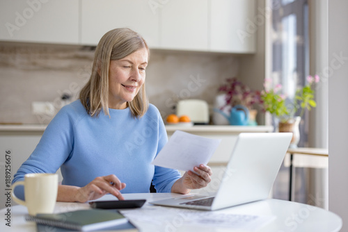Tableau sur toile Senior woman is confidently managing personal finances and household bills, revi