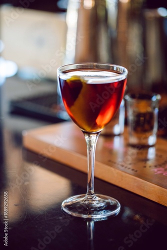 a glass of liquor in a nick and nora glass at a high end bar and restaurant