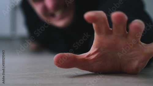 A man screams for help while lying on the floor.
He is experiencing leg problems after a heart attack.
The man screams loudly and asks for help.