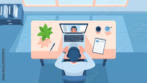 Person working on laptop at desk with documents and plant in a modern office setting viewed from behind