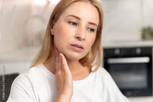 Free Download Woman checking her neck for lymph nodes while experiencing sore throat symptoms - GFXLoad