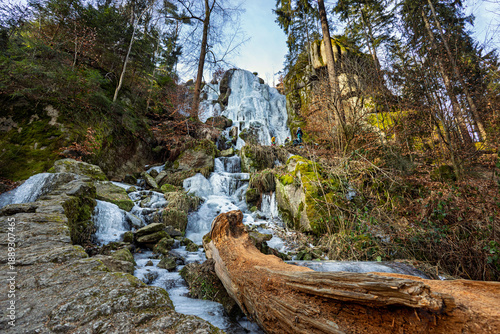 Cuadro en lienzo Wide angle view of ice covered and frozen Blauenthal waterfall with a fallen tre