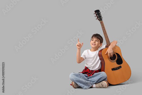 Cute boy with guitar pointi...