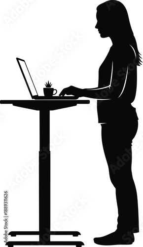 Silhouette of a woman working on a laptop at a standing desk