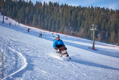 Foto Active recreation in the mountains - a man in a blue jacket confidently skis dow