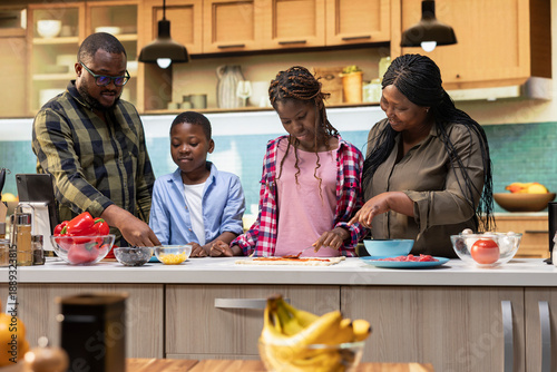 Foto Parents teaching interested kids how to make homemade pizza, children being involved and learning to cook in the kitchen together