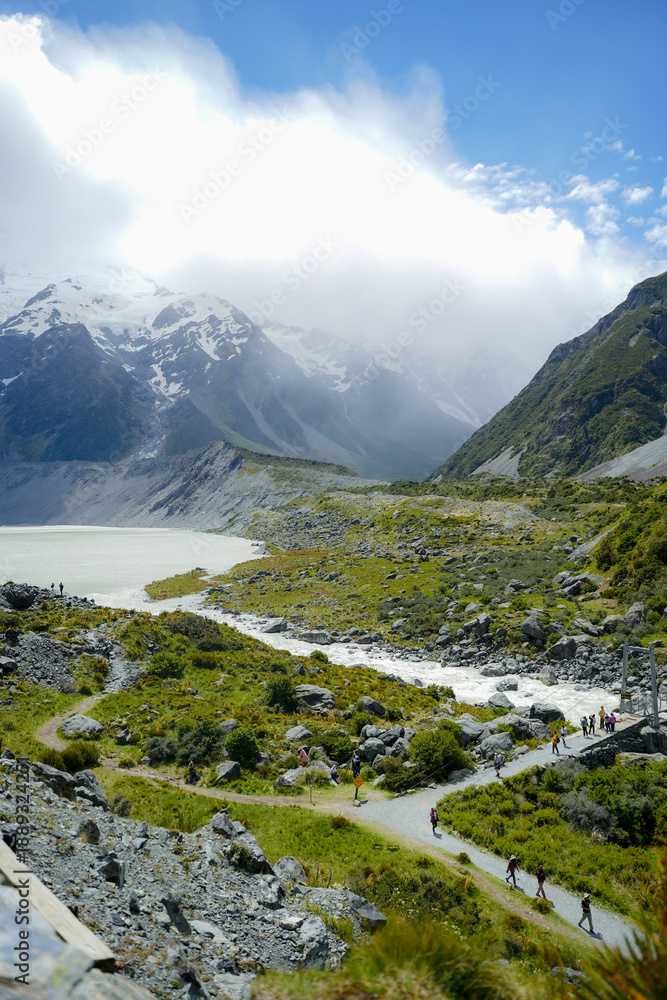 Fototapeta premium Hikers Walking Through Hooker Valley Track in Aoraki Mount Cook National Park