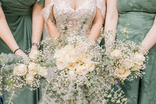 Bride and bridesmaids holding white rose bouquets and baby breath's flowers 