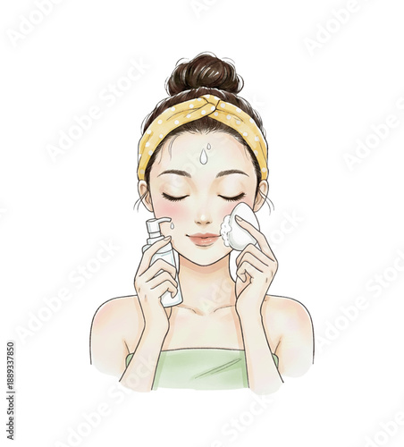 Asian woman serenely cleaning her face with a cleanser and facial tool wearing a yellow headband beauty routine
