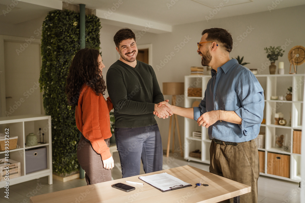 Fototapeta premium Couple shaking hands with real estate agent closing deal