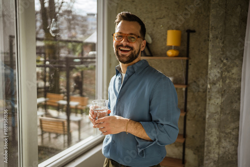 Obraz na płótnie Smiling man enjoying healthy water hydration at home