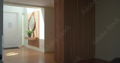 In entryway sunlight shifting through window is sliding light patch beside partition as day passes