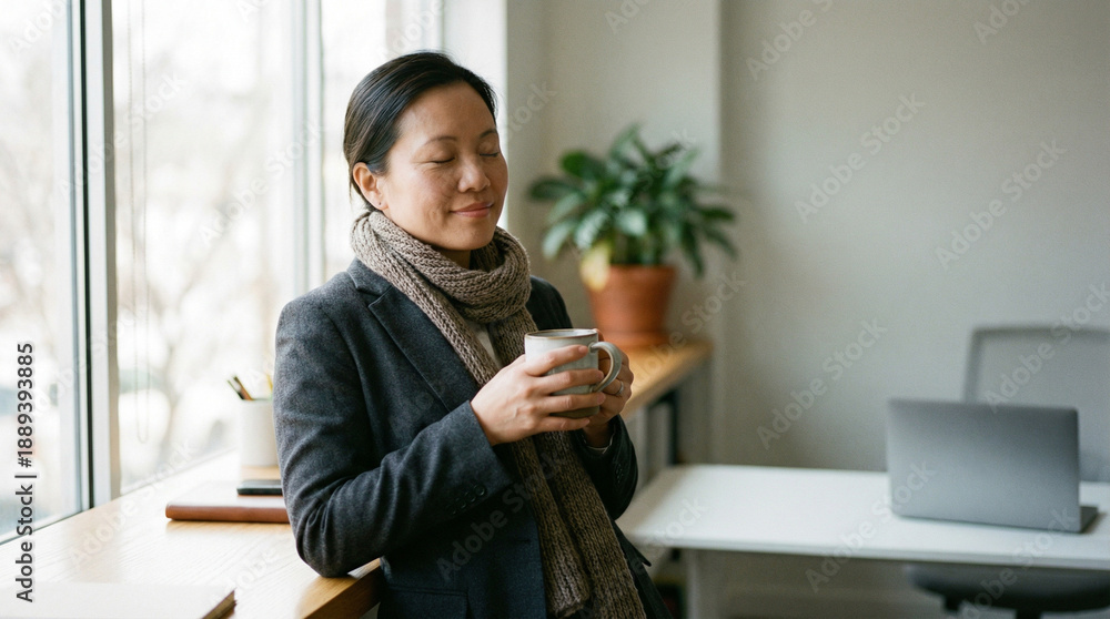 Fototapeta premium Content Businesswoman Enjoying a Relaxing Coffee Break by Office Window