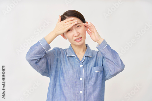 パジャマ姿の女性　発熱と頭痛　白背景