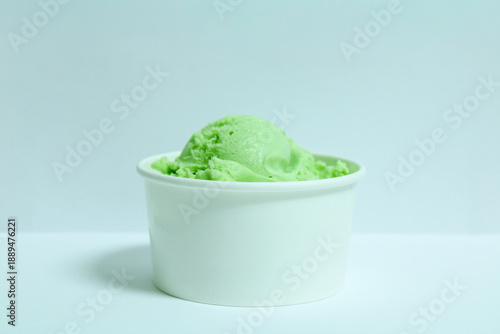 pistachio ice cream in small cup, delicious ice cream served in paper cup, pistachio flavored, white background