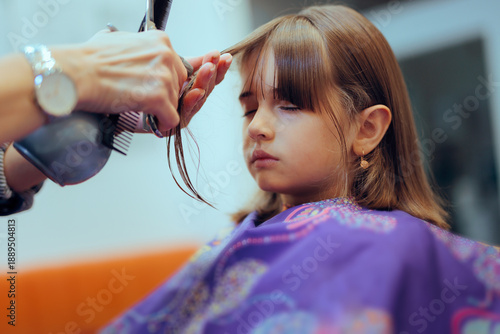 Foto Hairdresser Cuts Bangs for a Six Year Old Girl