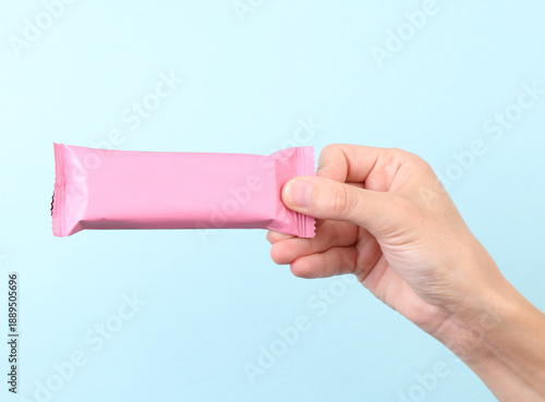 Photos Hand holding Chocolate bar pack mockup on blue background