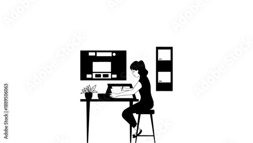 A woman working on her laptop at a desk with a large computer monitor