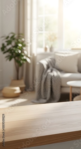 Blurred cozy living room interior with a wooden table in the foreground and bright sunlight streaming through a window.