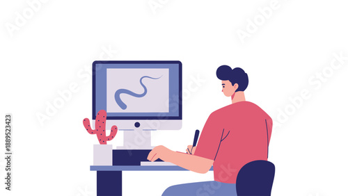 A man sitting at a desk working on a computer with a cactus nearby