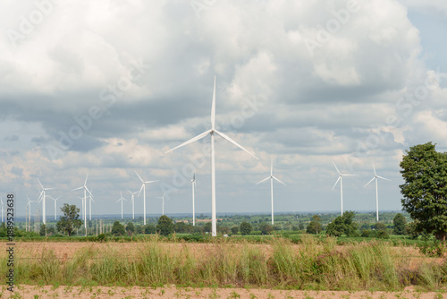 Wide wind landscape showing multiple turbine rotating across open field producing renewable power supporting green energy generation sustainable technology future innovation clean electric environment