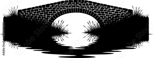 Small stone arch bridge reflection in water with reeds