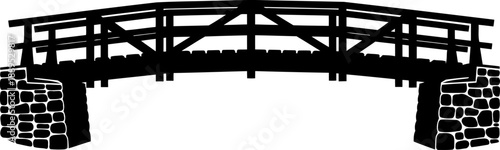 Rustic wooden footbridge silhouette with heavy fieldstone abutments