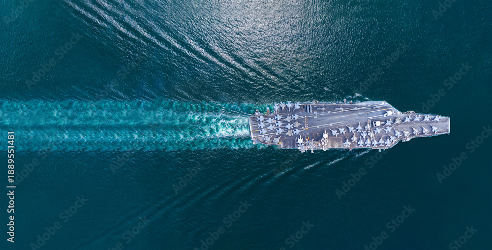 Obraz premium Nuclear ship warship Military navy ship carrier full loading fighter jet aircraft and Helicopters sailing in the ocean. Military warship deck loaded with fighter jets Naval defense power army force