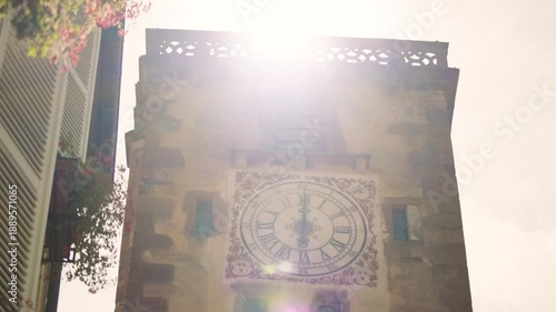 Historic clock tower illuminated by sunlight in understanding town center of Ribeauville, France
