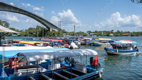 Río Dulce, Guatemala – View of Lake Izabal at the river’s source, a key ecotourism hub and gateway to rainforest canyons and Caribbean waters, with the Puente de Río Dulce in the background.