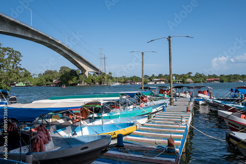 Río Dulce, Guatemala – View of Lake Izabal at the river’s source, a key ecotourism hub and gateway to rainforest canyons and Caribbean waters, with the Puente de Río Dulce in the background.