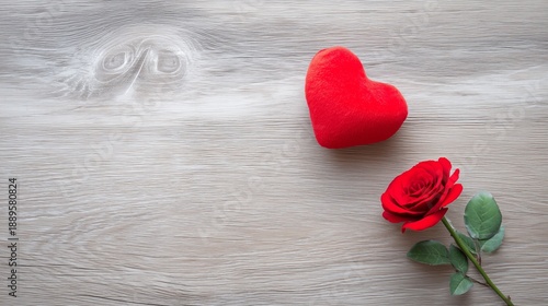 Red plush heart and rose expressing love and romance on a light wooden table with copy space