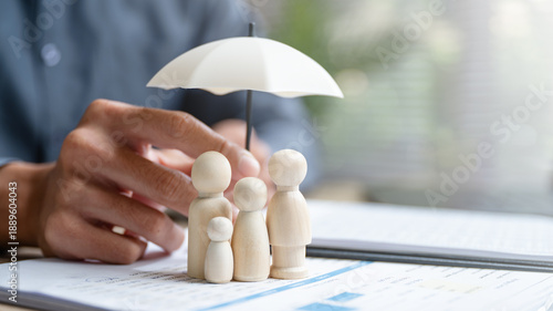 Foto Life insurance concept showing family figures protected under umbrella on policy documents