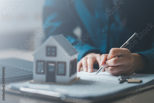 Bilde på lerret Home buyer calculating mortgage loan and interest rate with documents and house model