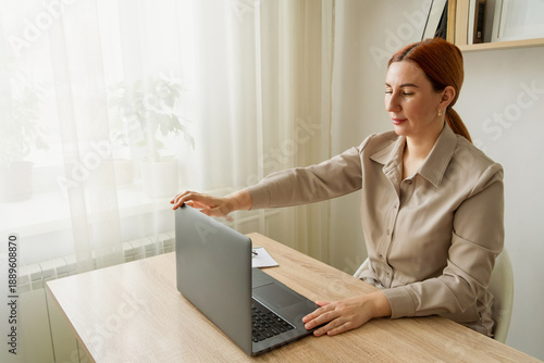 Woman closing laptop finishing online remote work day