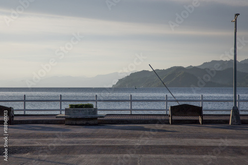 idyllic promenade bay walk along a sea wall with benches for relaxing